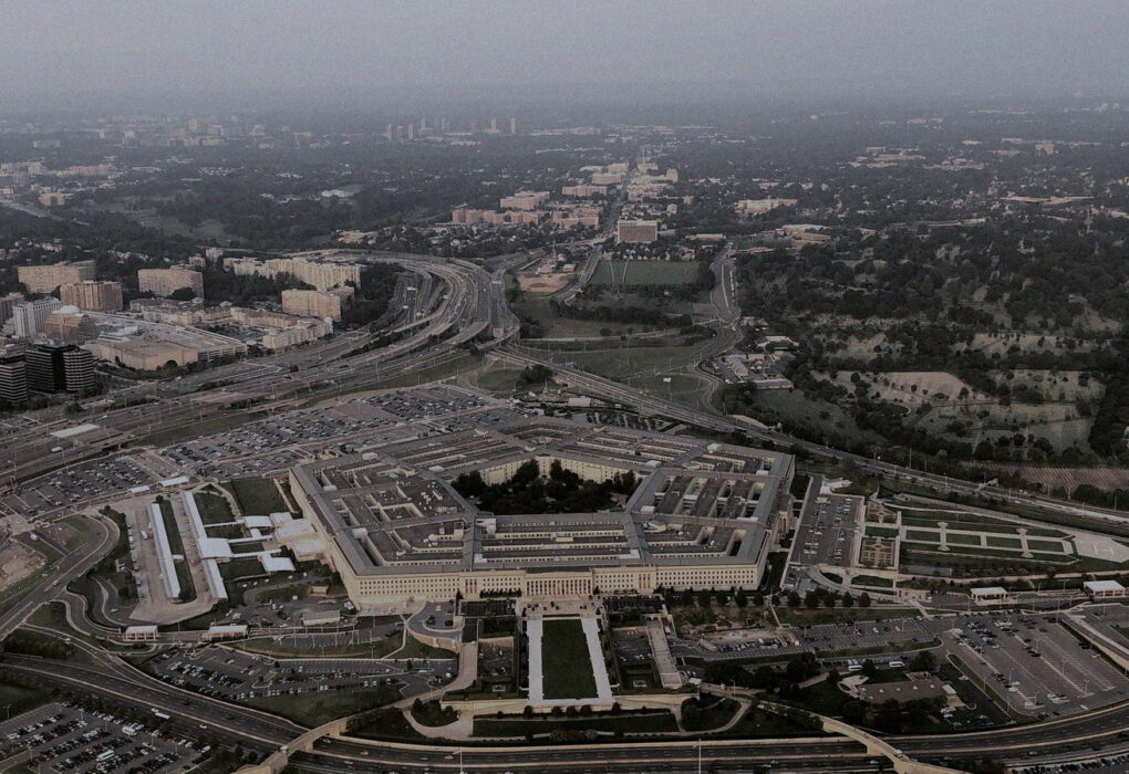 Aerial of the Pentagon building and surrounding highways from altitude, no people or brand logos — government workplace architecture mood
