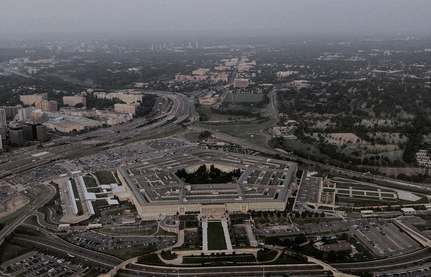 Aerial of the Pentagon building and surrounding highways from altitude, no people or brand logos — government workplace architecture mood