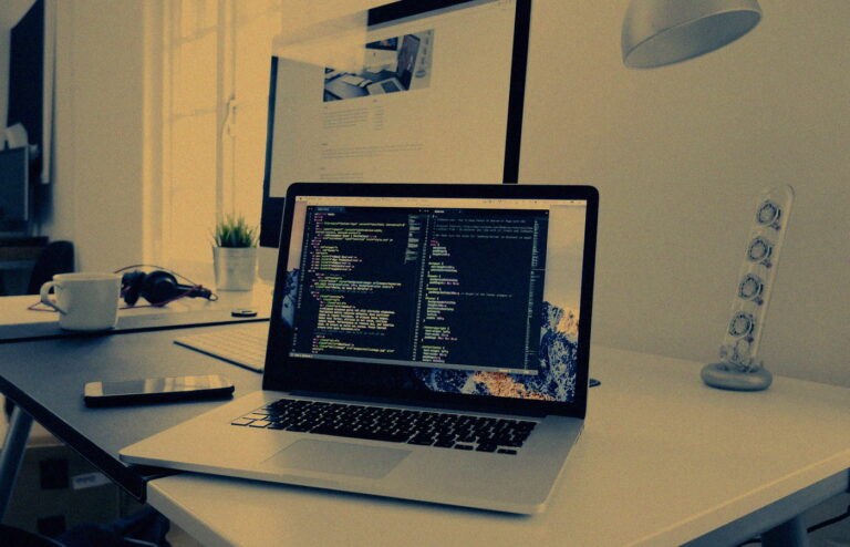 Dim developer desk with a glowing terminal and soft clustered lights, no people or logos