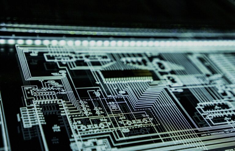 Angled close-up of a glowing teal circuit schematic panel on a dark surface, face-free cybersecurity still for Anthropic distillation and Moonshot IPO coverage