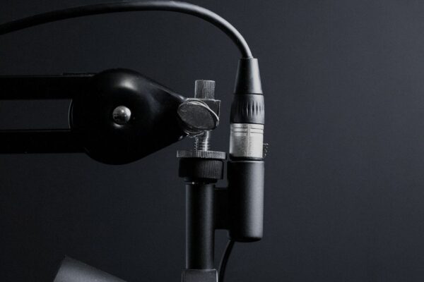 Face-free Unsplash photograph of a studio microphone on a boom arm against a dark background — related still for Google Gemini 3.8 Live speech-to-speech models September 2026