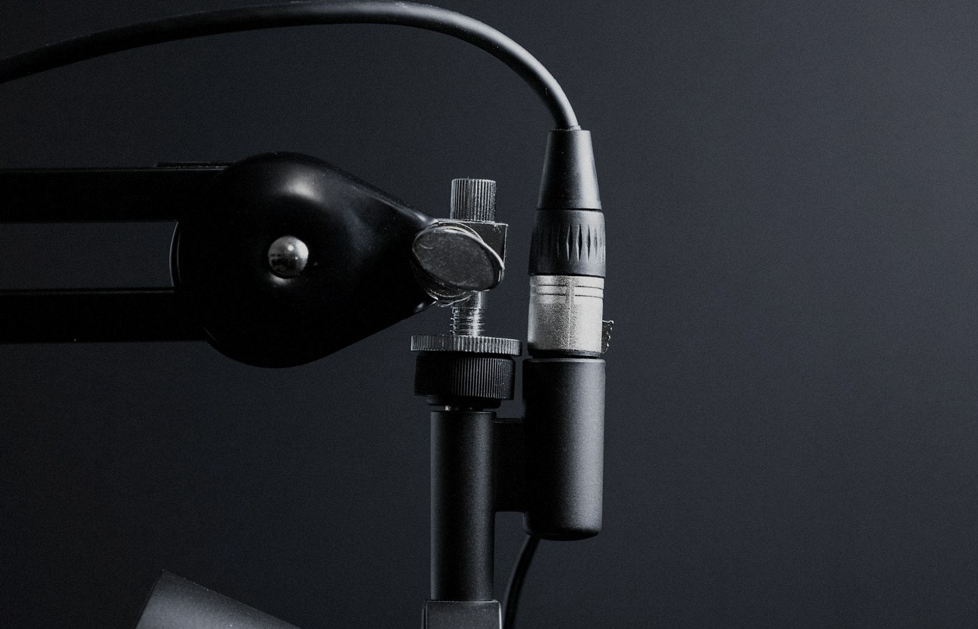 Face-free Unsplash photograph of a studio microphone on a boom arm against a dark background — related still for Google Gemini 3.8 Live speech-to-speech models September 2026