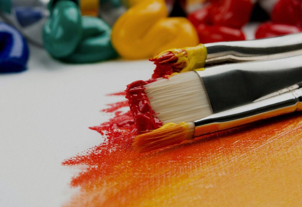 Face-free close-up of silver paint brushes with red and yellow paint on a white canvas — creative still for Microsoft MAI-Image-2.6 Foundry public preview coverage