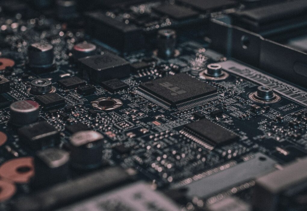 Face-free Unsplash macro of black circuit board and chipset still — hero for Google Mechanize talent deal bringing staff into midtraining and DeepMind September 2026