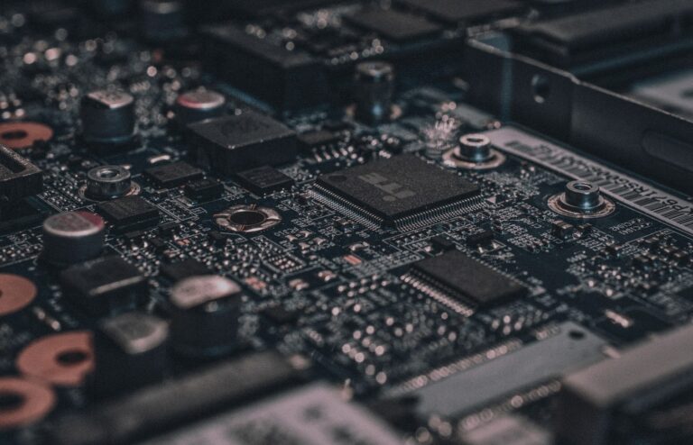 Face-free Unsplash macro of black circuit board and chipset still — hero for Google Mechanize talent deal bringing staff into midtraining and DeepMind September 2026