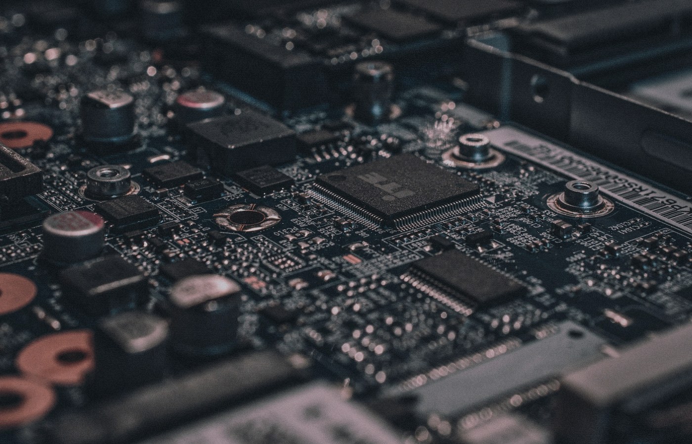 Face-free Unsplash macro of black circuit board and chipset still — hero for Google Mechanize talent deal bringing staff into midtraining and DeepMind September 2026