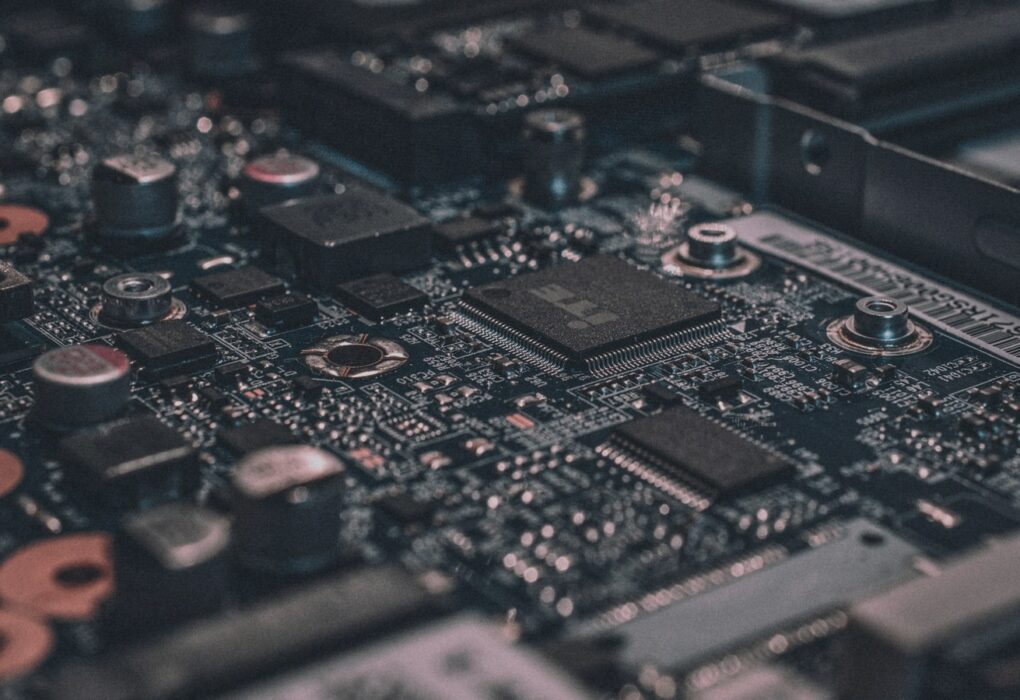 Macro photograph of a dark computer circuit board with shallow depth of field, face-free abstract compute still for Meta Muse Spark 1.3 agentic coding coverage