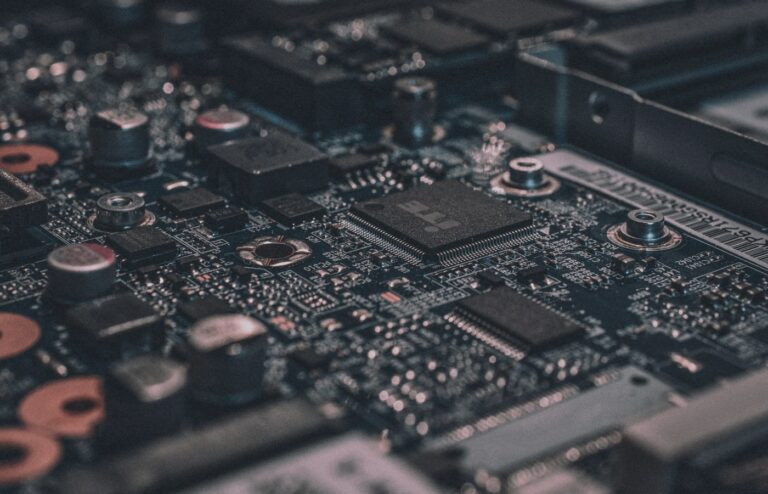Macro photograph of a dark computer circuit board with shallow depth of field, face-free abstract compute still for Meta Muse Spark 1.3 agentic coding coverage