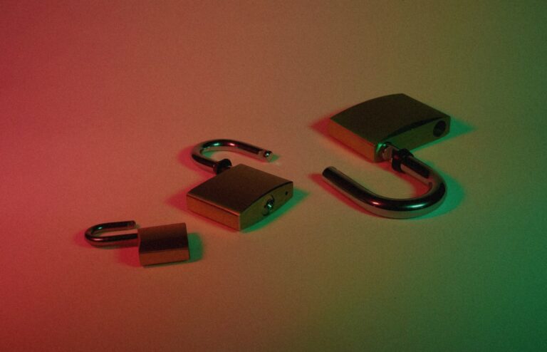 Three open brass padlocks on a surface under red-to-green dramatic lighting, face-free still for OpenAI Astra Critical cybersecurity capability