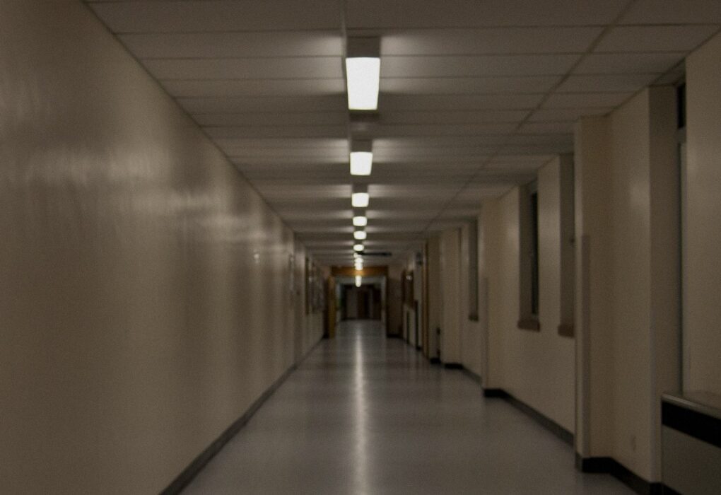 Empty hospital corridor with a row of ceiling lights receding into the distance, no people, no logos, used as a still for clinical chart systems