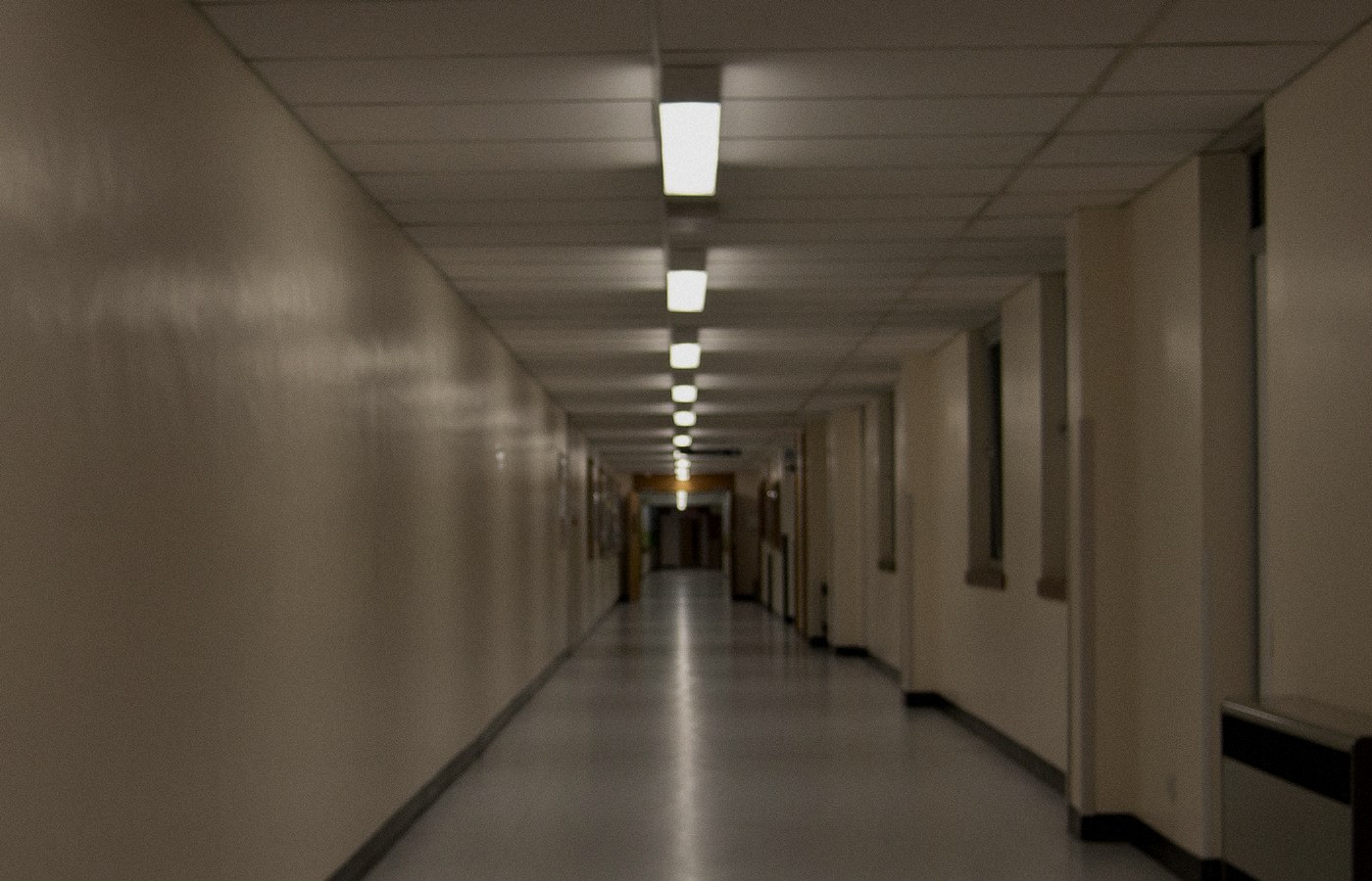 Empty hospital corridor with a row of ceiling lights receding into the distance, no people, no logos, used as a still for clinical chart systems
