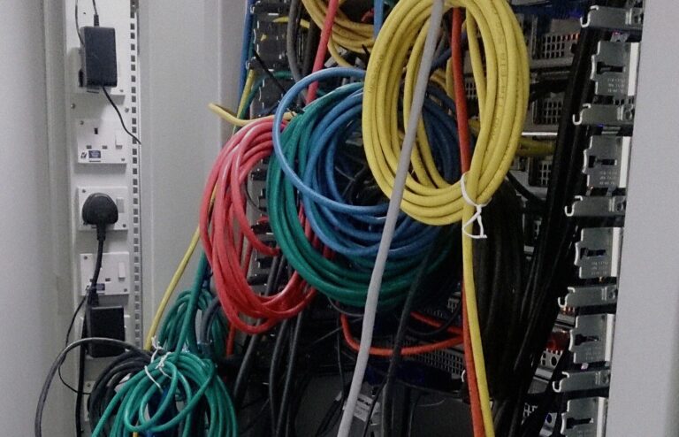 Face-free close-up of dense network cables and patch connections in a server room — still for OpenAI German wiki incident and misalignment reporting framework coverage