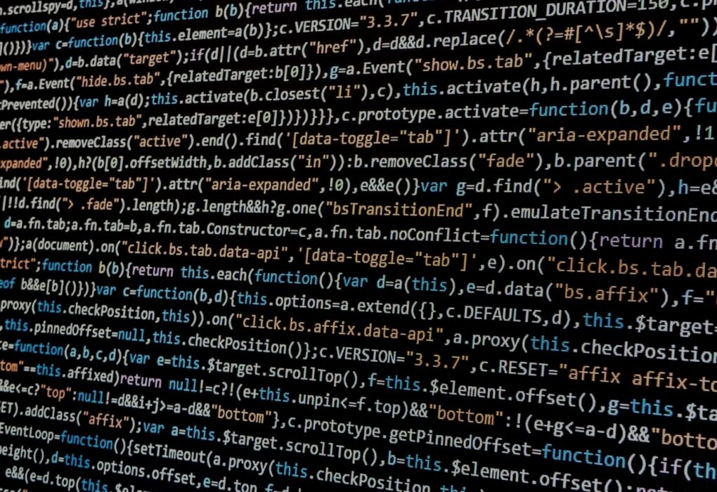 Close-up of JavaScript code on a dark computer display, illustrating conventional coded interfaces without people or logos