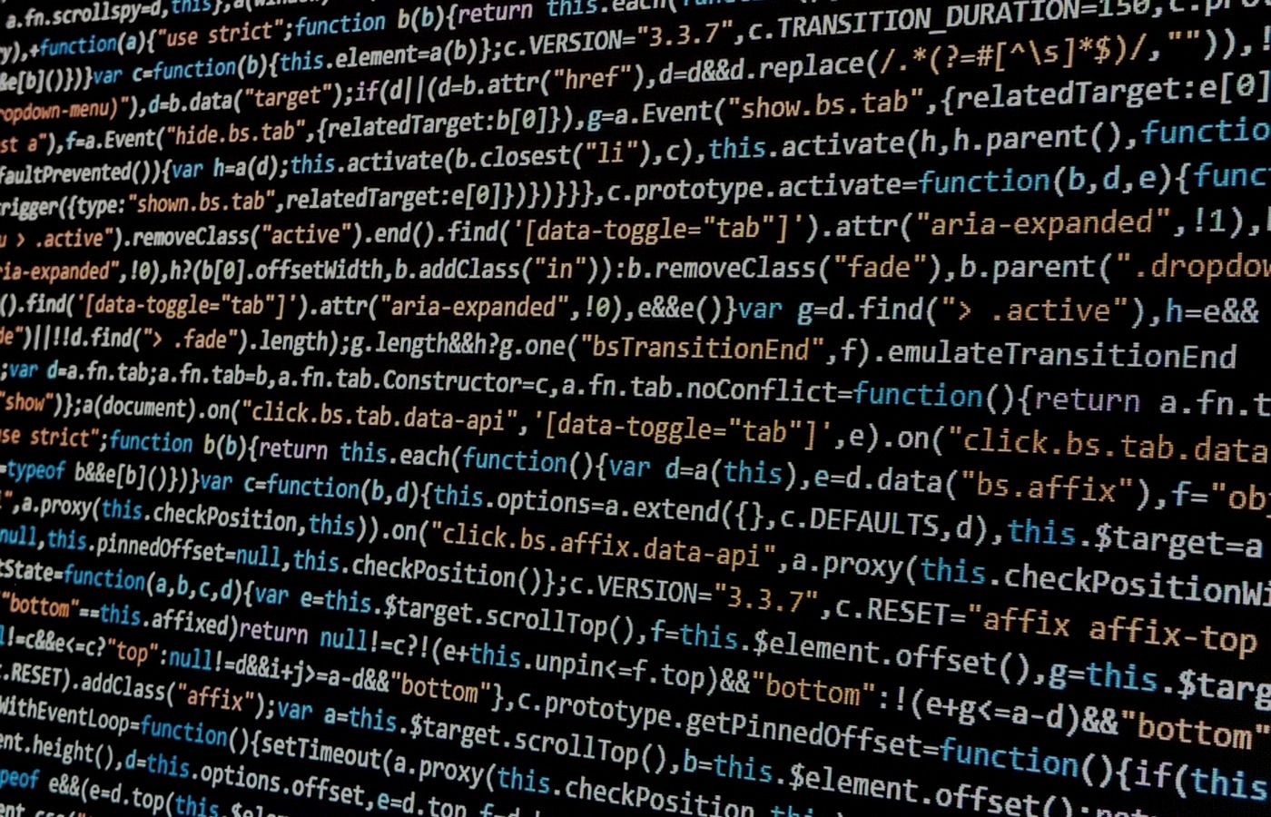 Close-up of JavaScript code on a dark computer display, illustrating conventional coded interfaces without people or logos