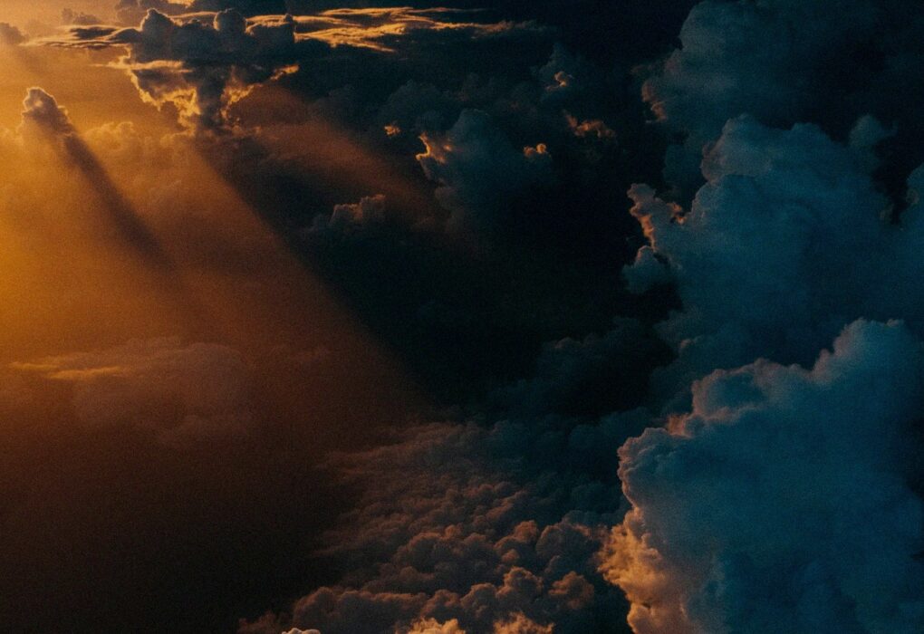 Face-free storm clouds during golden hour over a dark landscape — related still for Google WeatherNext 3 hourly weather AI coverage