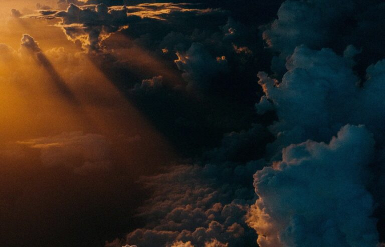 Face-free storm clouds during golden hour over a dark landscape — related still for Google WeatherNext 3 hourly weather AI coverage